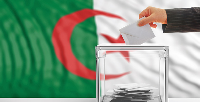 Wahlurne vor Flagge Algeriens