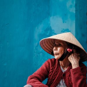 Alte Vietnamesin unter einem asiatischen Strohhut