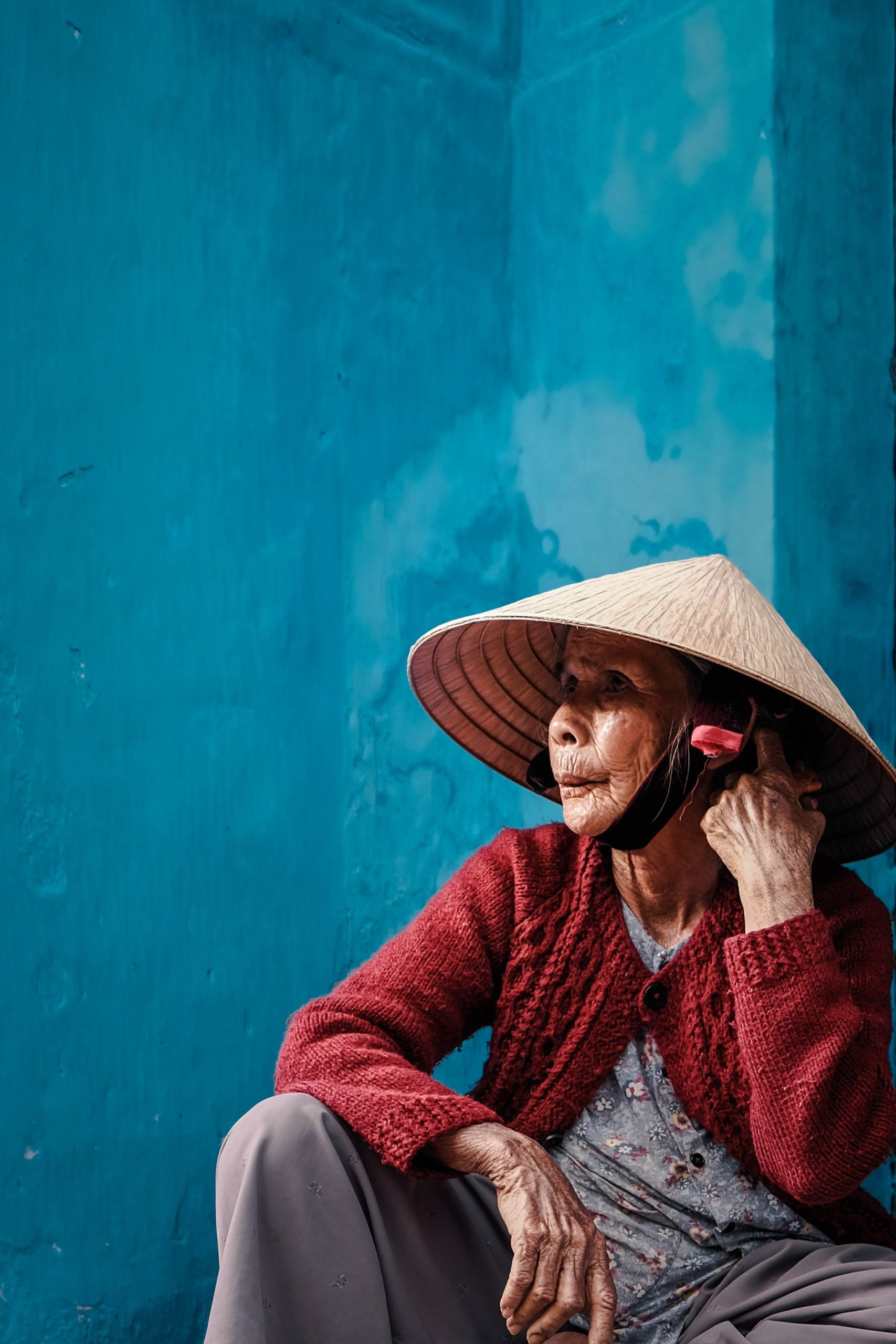 Alte Vietnamesin unter einem asiatischen Strohhut