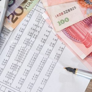 Steuerabrechnung neben Geldscheinen, Kugelschreiber und Taschenrechner.