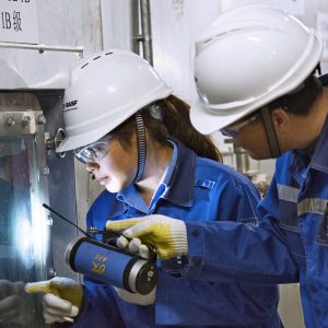 Miaomiao Jiao (links), Mitarbeiterin, und Hui Wang (rechts), Schichtleiter, schauen durch das Kontrollfenster des Wirbelschichttrockners, um das Produkt im BASF-Flockungsmittelwerk in Nanjing/China zu überprüfen.